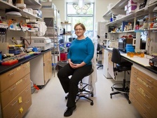 a woman seated between two lab benches